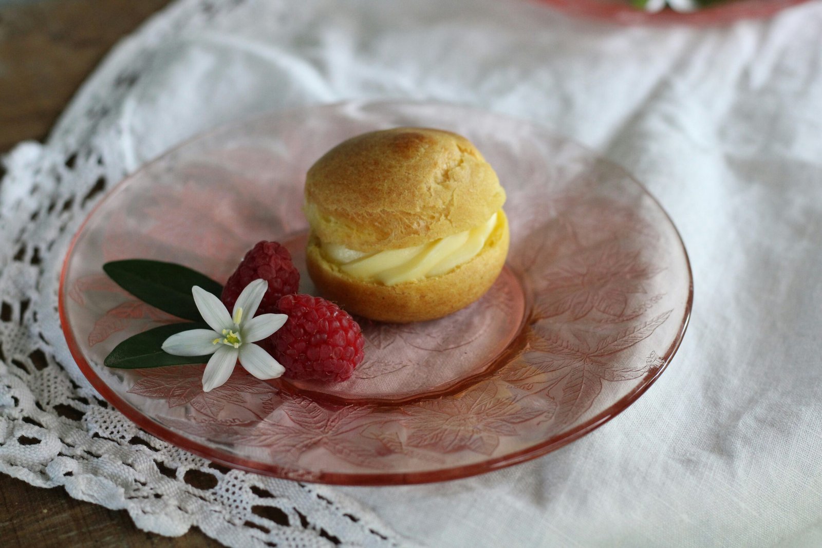 a plate with a muffin and raspberries on it