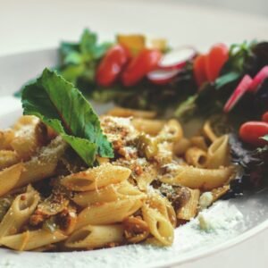 a white plate topped with pasta and vegetables